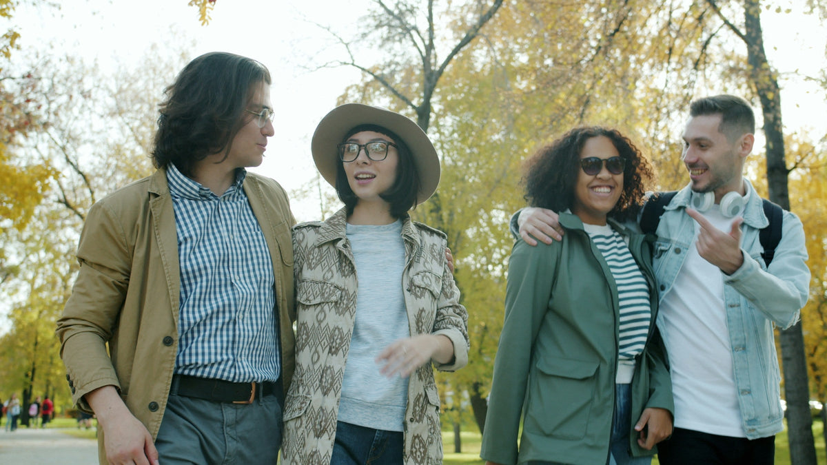 Happy young couples are walking outdoors in park on sunny autumn day talking smiling having fun. Communication, youth and modern lifestyle concept.